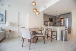 a kitchen and dining room with a table and chairs at Stunning Apartment in Downtown Doral in Miami