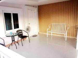 a living room with a table and chairs and a chair at SUKANO Apartment VIP in Ban Khlong Chao