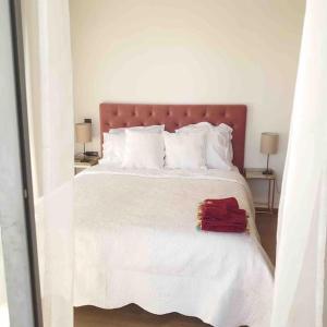 um quarto com uma cama branca e uma toalha vermelha em Luxe résidence Hivernage em Agadir