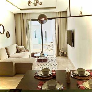 uma sala de estar com um sofá e uma mesa em Luxe résidence Hivernage em Agadir
