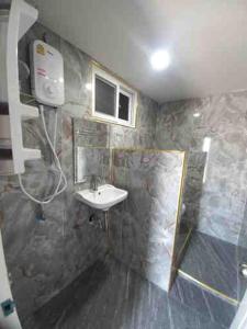 y baño con lavabo y ducha. en SUKANO Apartment VIP, en Ban Thap Nang