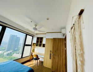 um quarto com uma ventoinha de tecto, uma cama e uma secretária em BOM HOMES- ECOPARK- SERVICE APARTMENt em Kim Quan