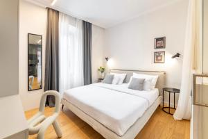 a white bedroom with a white bed and a chair at MAROEN 3 Lux Apartment Old Town in Split