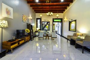 a living room with a television and a dining room at The Egerton Melaka in Malacca