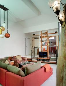 ein Wohnzimmer mit einer roten Couch in einem Zimmer in der Unterkunft Lovely 2BR Apt w Balcony in Neve Tzedek Area Sea N' Rent in Tel Aviv