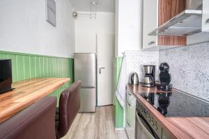 a kitchen with a refrigerator and a counter top at Homefy Sleep & Relax Apartment mit frei parken, in Toplage in Essen