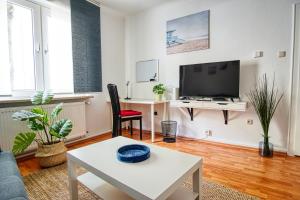 a living room with a tv and a table at Homefy Sleep & Relax Apartment mit frei parken, in Toplage in Essen