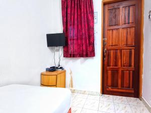 1 dormitorio con cama, cortina roja y puerta en Chalet Yunie Marang by RVH, 