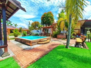 a backyard with a swimming pool and grass at Chalet Yunie Marang by RVH 
