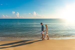 a man and a woman walking on the beach at Wyndham Garden Hoi An Cua Dai Beach in Hoi An