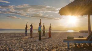 a group of people doing yoga on the beach at Wyndham Garden Hoi An Cua Dai Beach in Hoi An