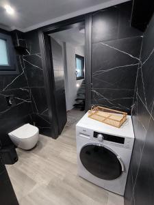 a bathroom with a washing machine and a toilet at ZOE LOFT in Kavála +31 photos