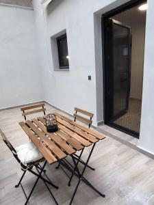 a wooden table and two chairs in a room at ZOE LOFT in Kavála