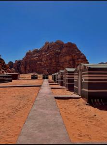 a pathway in the desert with a mountain in the background at Wadi Rum Jordan Camp in Wadi Rum