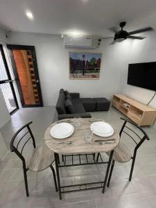 a living room with a table and chairs and a couch at Canlubang Luxury Apartment in Canlubang