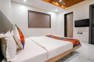 a bedroom with a bed and a flat screen tv at FabHotel Ansh in Aurangabad