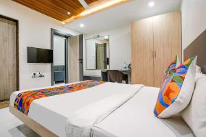 a bedroom with a large white bed and a television at FabHotel Ansh in Aurangabad