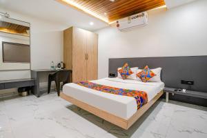 a bedroom with a bed and a desk and a television at FabHotel Ansh in Aurangabad
