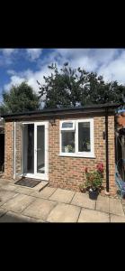 a small brick house with two windows and a porch at Tranquil Escape in Tilehurst