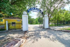 een toegang tot een poort in een park met een hek bij Chaika Gostinichny Kompleks in Karagandy