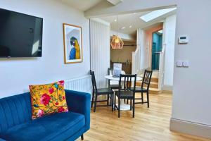 a living room with a blue couch and a dining room at No 9 The Folly in Southport