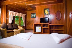 a bedroom with a bed and a tv and a couch at Dreamland Resort in Thong Nai Pan Yai