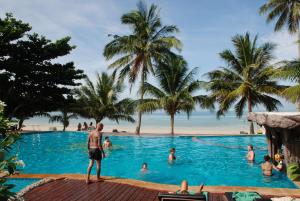 un uomo in piedi nella piscina di un resort di Dreamland Resort a Thong Nai Pan Yai