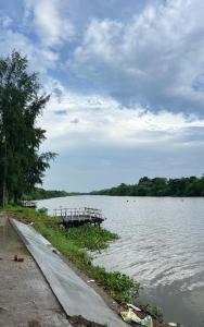 a dock in the middle of a body of water at Damodar River Retreat, Uluberia in Uluberiya