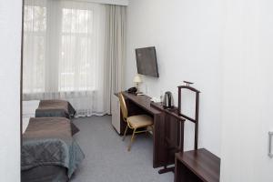 Habitación de hotel con 2 camas y escritorio con ordenador en Chaika Gostinichny Kompleks en Karagandá