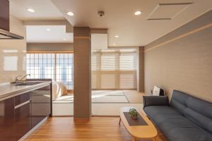 sala de estar con sofá y cocina en 谷町君・星Hotel・道頓福居 en Osaka