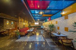 a restaurant with tables and chairs in a room at Inde Signature Jaipur in Jaipur