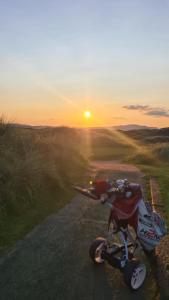 a motorcycle parked on a road with the sunset in the background at Coastal Heaven Downings in Downings
