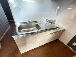 a kitchen with a stainless steel sink in a room at BiBi Hotel コンベンションベイ in Ginowan