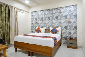 1 dormitorio con 1 cama grande en una habitación en FabHotel ATS Inn, en Pune