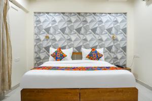 1 dormitorio con 1 cama blanca grande con almohadas coloridas en FabHotel ATS Inn, en Pune