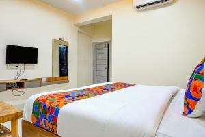 1 dormitorio con 1 cama y TV de pantalla plana en FabHotel ATS Inn, en Pune