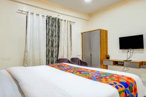 Habitación de hotel con cama y TV de pantalla plana. en FabHotel ATS Inn, en Pune