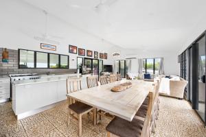 eine Küche und ein Esszimmer mit einem Holztisch und Stühlen in der Unterkunft The Beach House by Anglers Choice in Dundee Beach