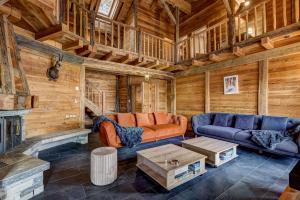 a living room with couches and a fireplace in a cabin at Chalet Alaska in La Tzoumaz