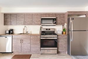 a kitchen with stainless steel appliances and wooden cabinets at Cozy 2 brm apartment mins away from United Center in Chicago