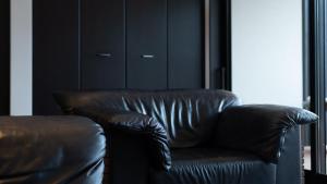a brown leather couch in a room with a window at Fugaku Gunjo in Izu