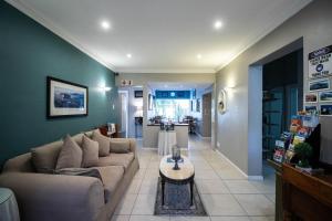 uma sala de estar com um sofá e uma mesa em Spring Tide Inn by CTHA em Cidade do Cabo