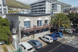 a building with cars parked in a parking lot at Spring Tide Inn by CTHA in Cape Town