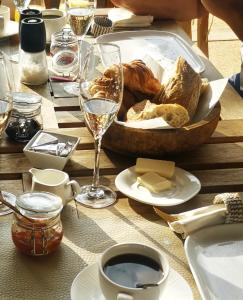 a table with a basket of bread and a glass of wine at La Maison Vanille in Ngaparou