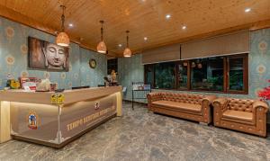 a waiting room with brown leather furniture and a counter at Treebo Tryst Tempo Heritage Spa & Resort in Gangtok