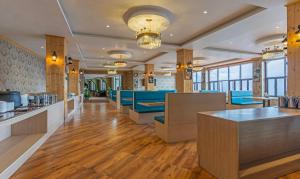 甘托克的住宿－Treebo Tryst Tempo Heritage Spa & Resort，餐厅设有蓝色的椅子和桌子以及窗户。