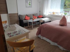 1 dormitorio con cama, sofá y mesa en Appartementhaus Tannenhof - Wohnung 2, en Haidmühle