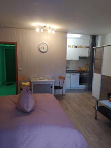 1 dormitorio con cama, mesa y reloj en Appartementhaus Tannenhof - Wohnung 2, en Haidmühle