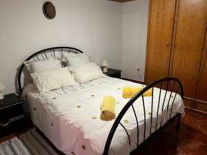 1 dormitorio con 1 cama con sábanas y almohadas blancas en Vivenda Ribeiro - Curral das Freiras en Curral das Freiras
