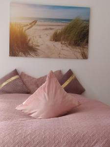 um quarto com uma cama rosa e uma fotografia na parede em Appartementhaus Tannenhof - Wohnung 2 em Haidmühle